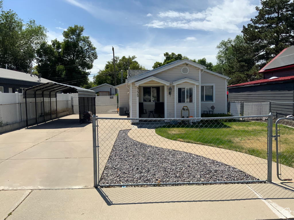 View of front facade featuring a carport, a gate, and driveway