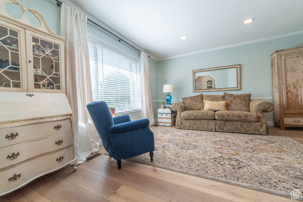 Living room featuring crown molding, wood finished floors, and recessed lighting