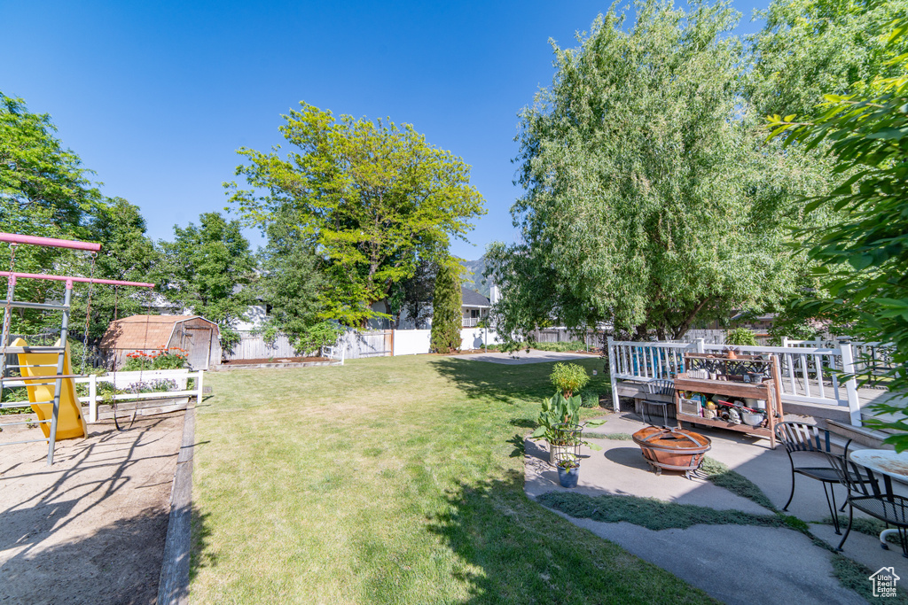 View of yard with an outdoor fire pit, a patio area, and a playground