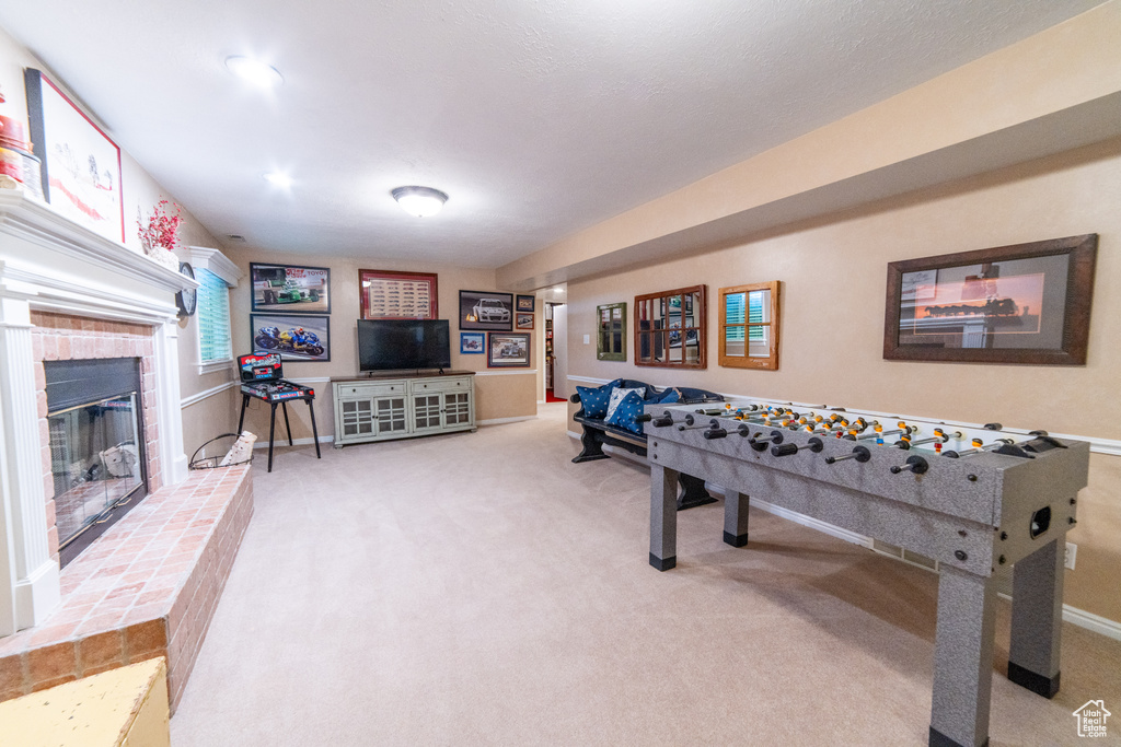 Rec room with carpet floors, a fireplace, and baseboards
