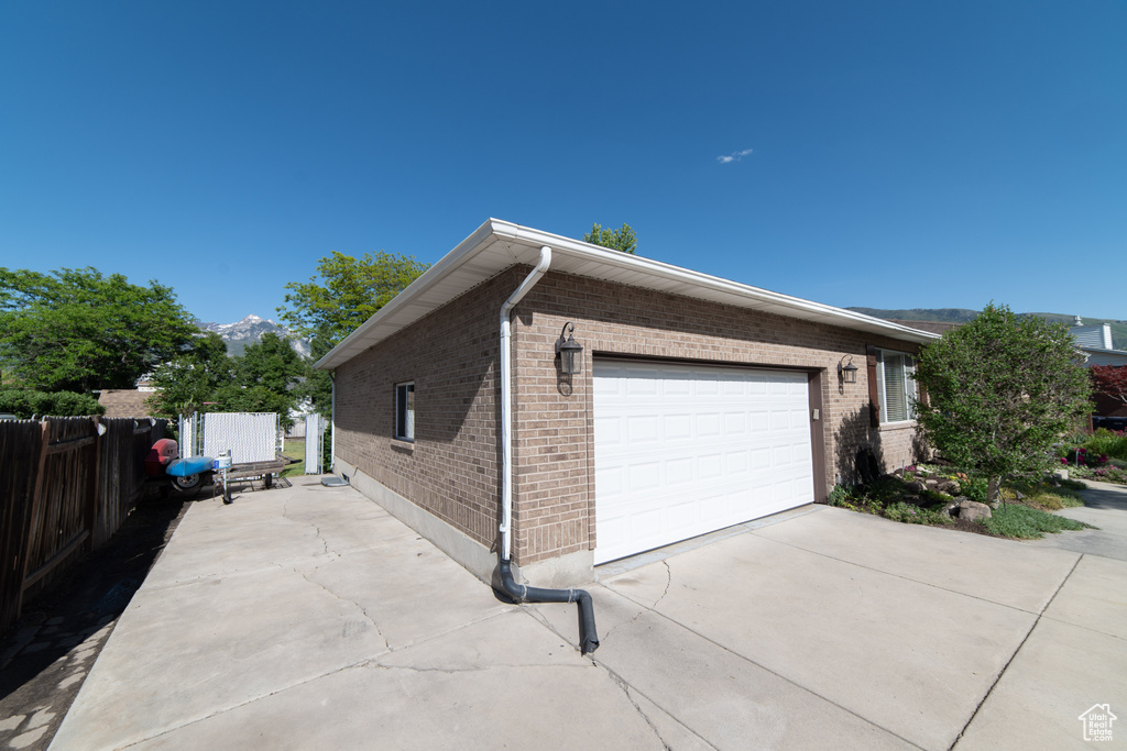 View of side of home featuring brick siding and driveway