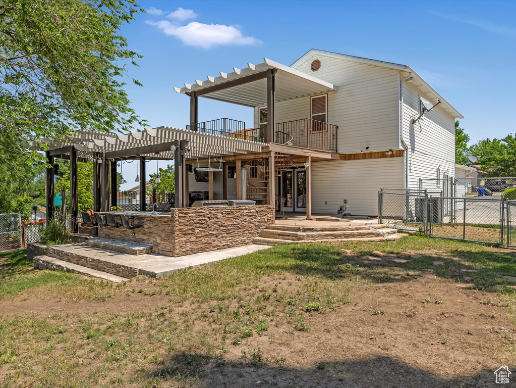 Rear view of property featuring a pergola, a gate, and a patio area
