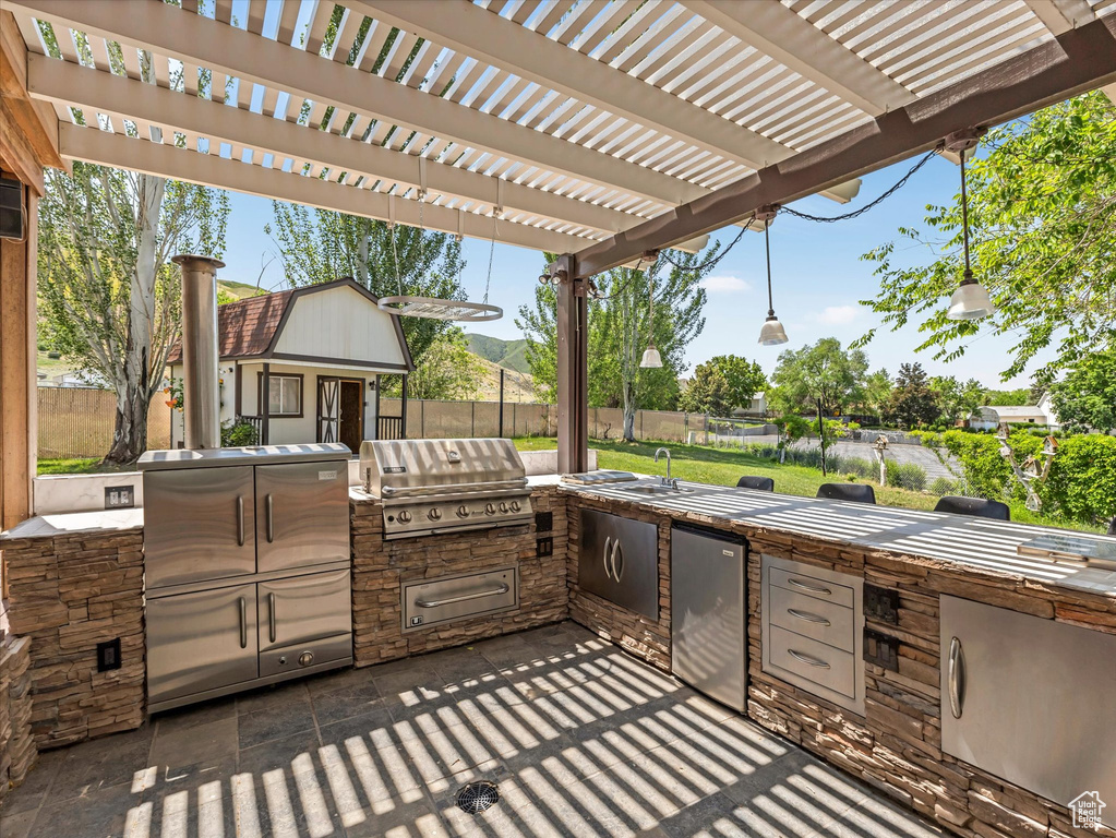 View of patio with a pergola, an outbuilding, and a sink