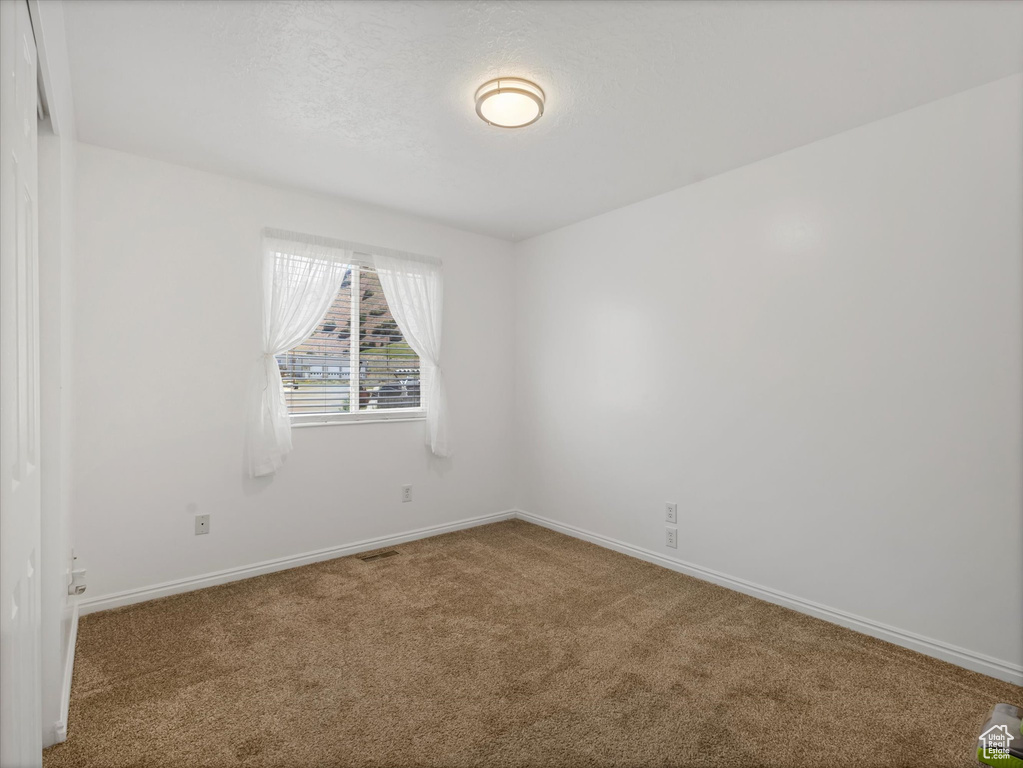 Carpeted spare room with baseboards