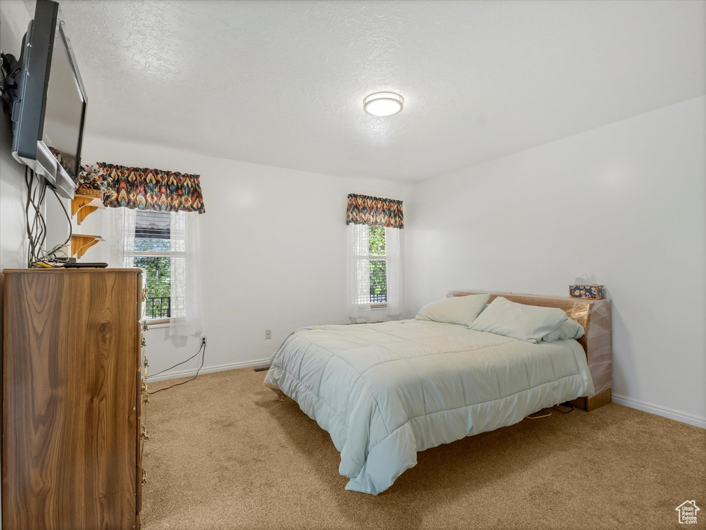 Carpeted bedroom with baseboards and a textured ceiling