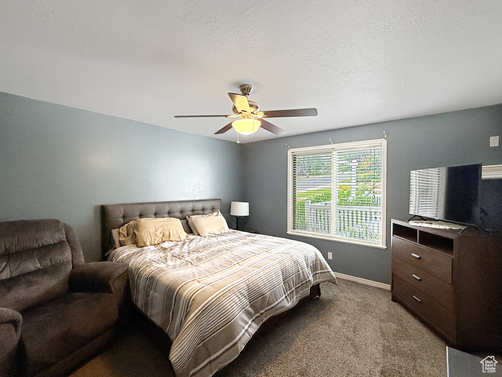 Bedroom featuring light carpet, baseboards, and a ceiling fan