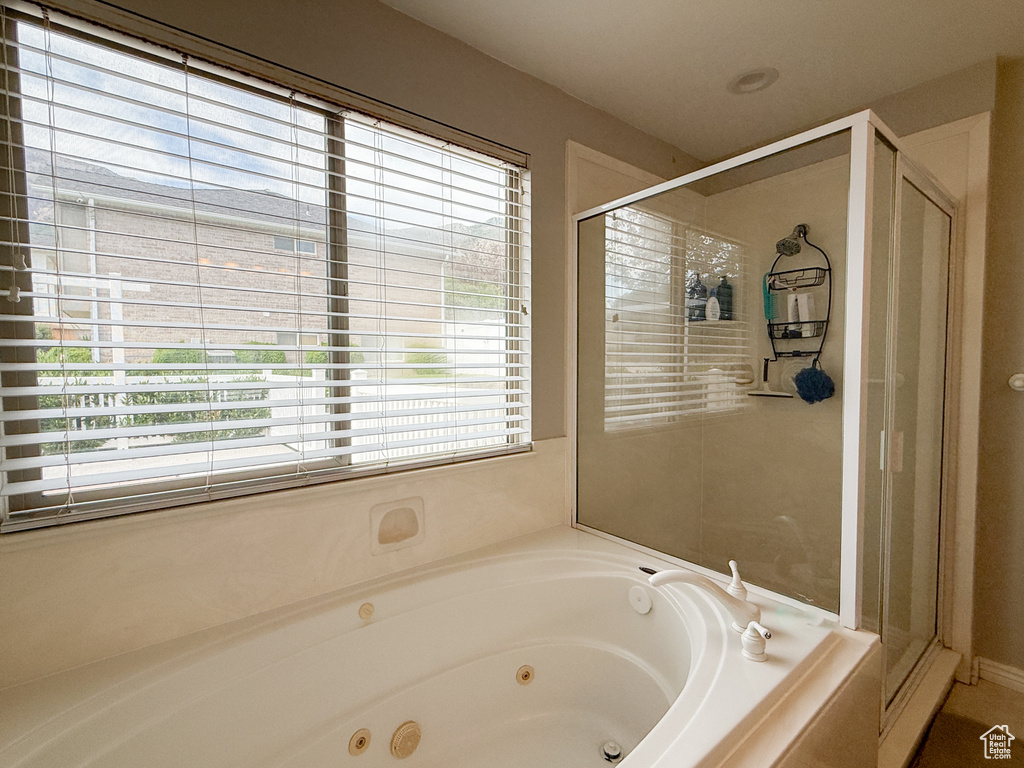 Bathroom featuring a whirlpool tub and a shower stall