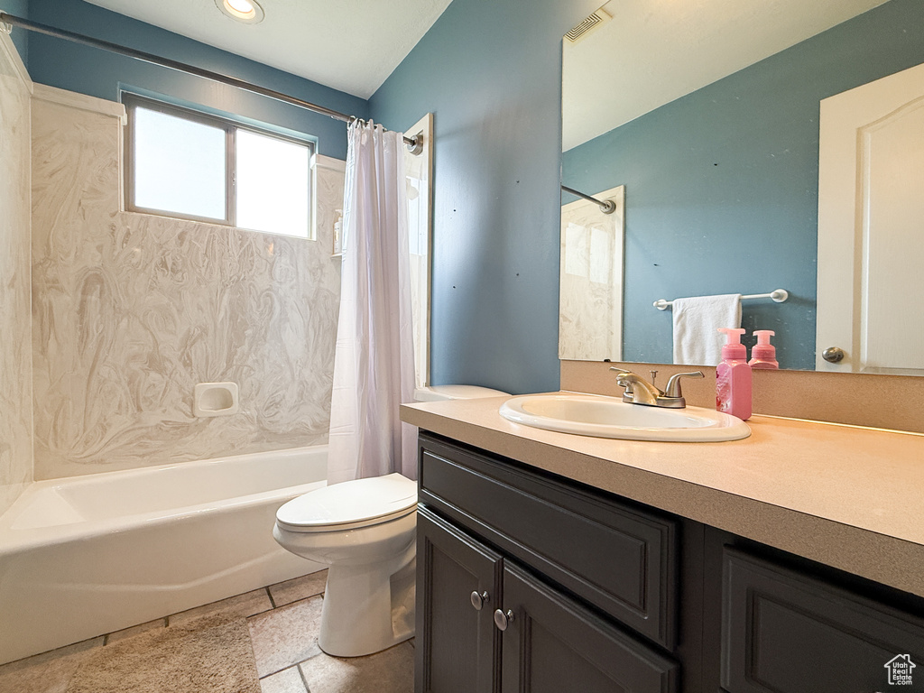 Bathroom featuring shower / bath combo, vanity, and toilet