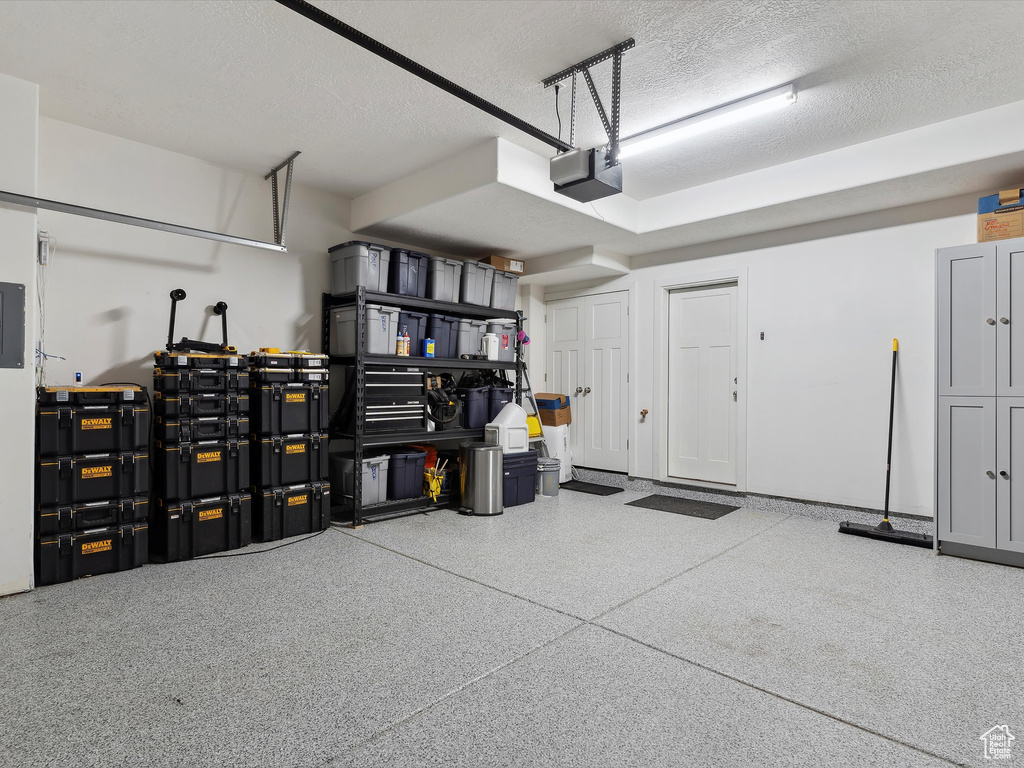 Garage featuring a garage door opener and electric panel