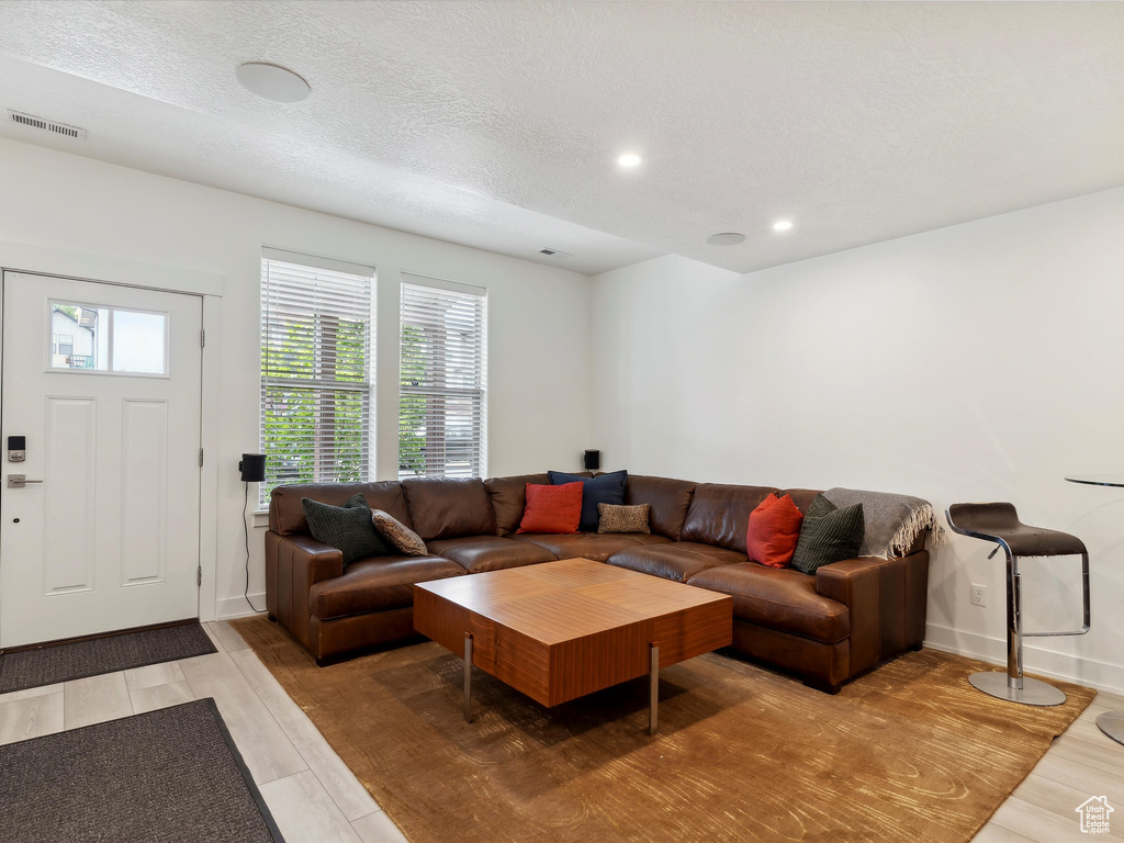 Living room featuring plenty of natural light, light wood-style flooring, recessed lighting, and baseboards