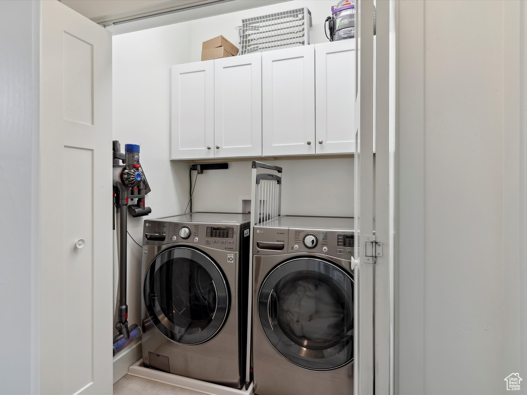 Washroom with cabinet space and washer and clothes dryer