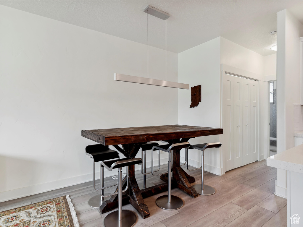 Dining space with light wood-type flooring and baseboards