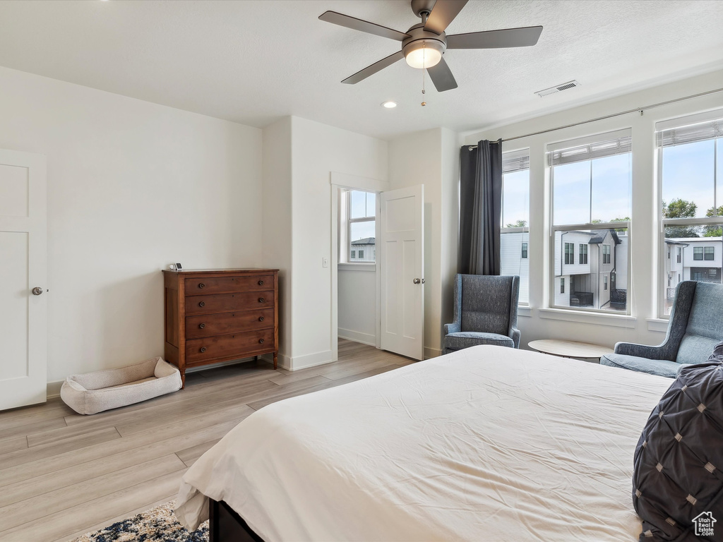Bedroom with multiple windows, light wood-type flooring, ceiling fan, baseboards, and recessed lighting