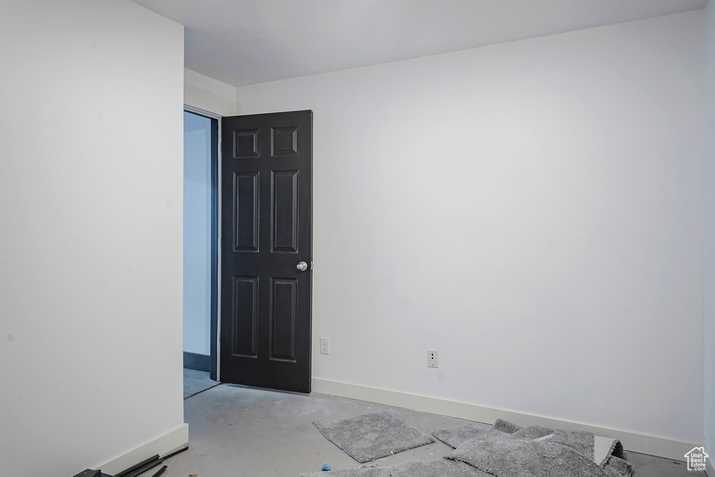 Empty room featuring baseboards and concrete flooring