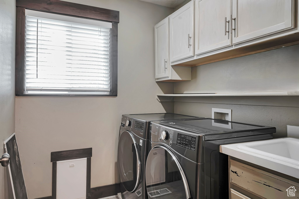 Laundry area featuring washer and dryer and cabinet space