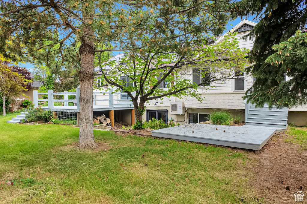 View of green lawn featuring a wooden deck