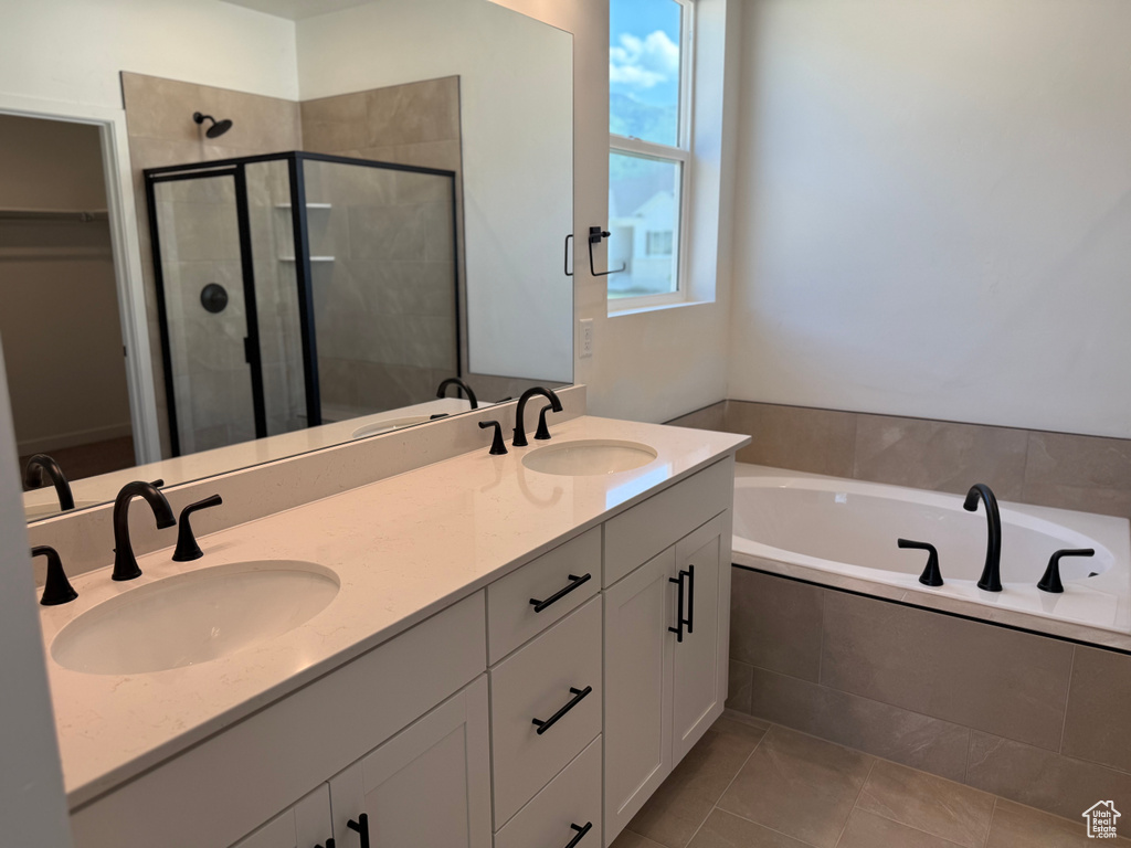 Full bath featuring a shower stall, a garden tub, a walk in closet, double vanity, and tile patterned flooring