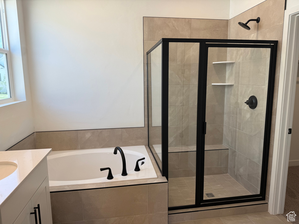 Full bath featuring a bath, a shower stall, vanity, and tile patterned floors