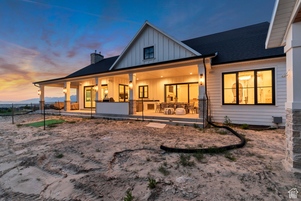 Rear view of property featuring board and batten siding and a chimney