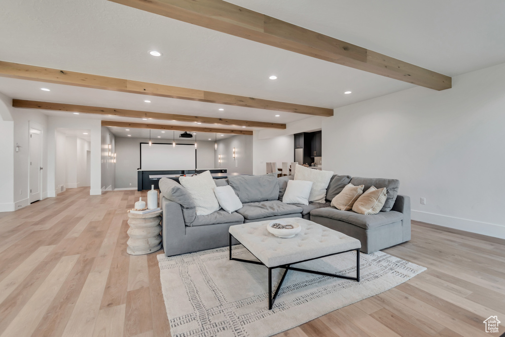 Living room with beamed ceiling, light wood-style flooring, recessed lighting, and baseboards