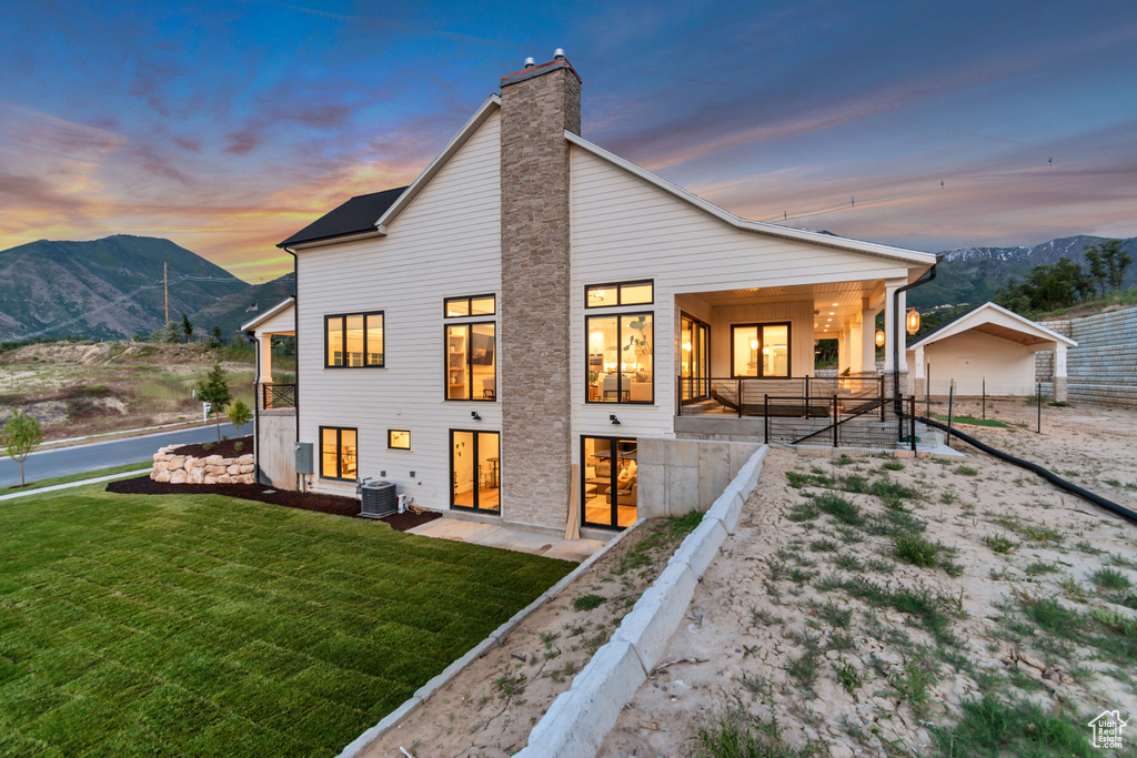 Back of property featuring a mountain view, central AC, and a chimney