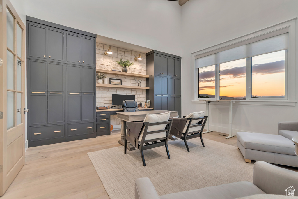Office space with built in desk and light wood-type flooring