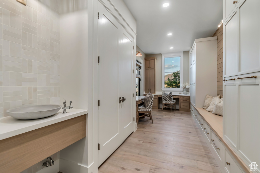 Bathroom featuring recessed lighting, wood finished floors, backsplash, and vanity