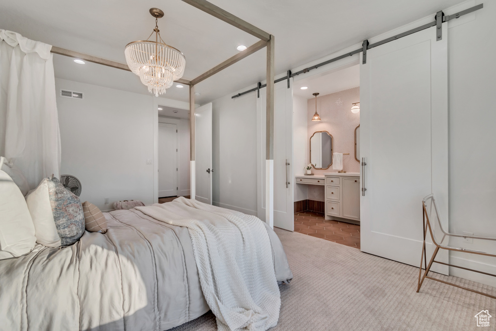 Carpeted bedroom featuring a barn door, recessed lighting, a chandelier, ensuite bathroom, and baseboards