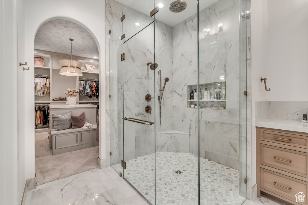 Bathroom with a marble finish shower and marble finish floors