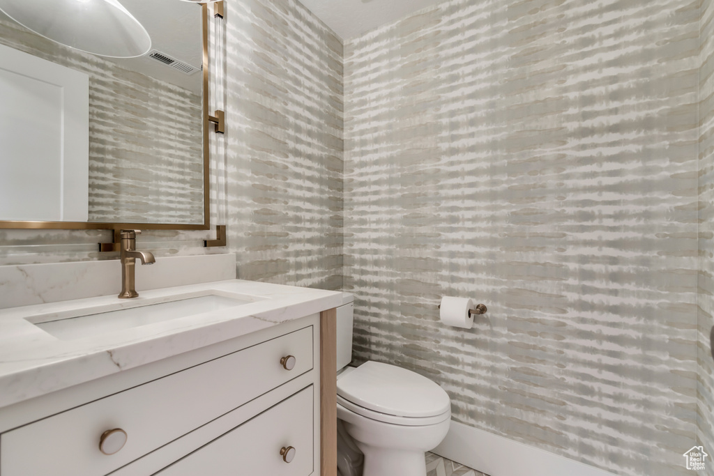 Bathroom with tile walls, vanity, and toilet