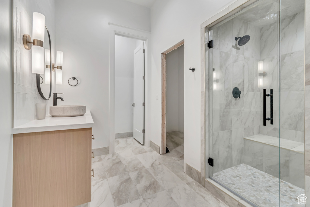 Bathroom with a stall shower, vanity, marble finish floors, and baseboards