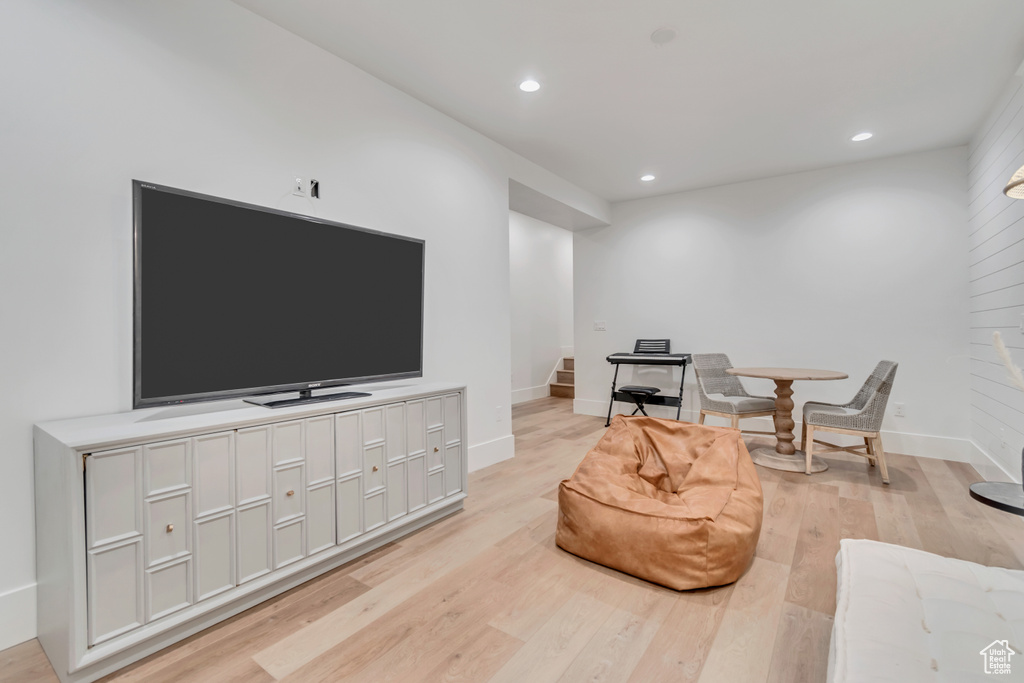 Living area with stairs, light wood-style flooring, recessed lighting, and baseboards