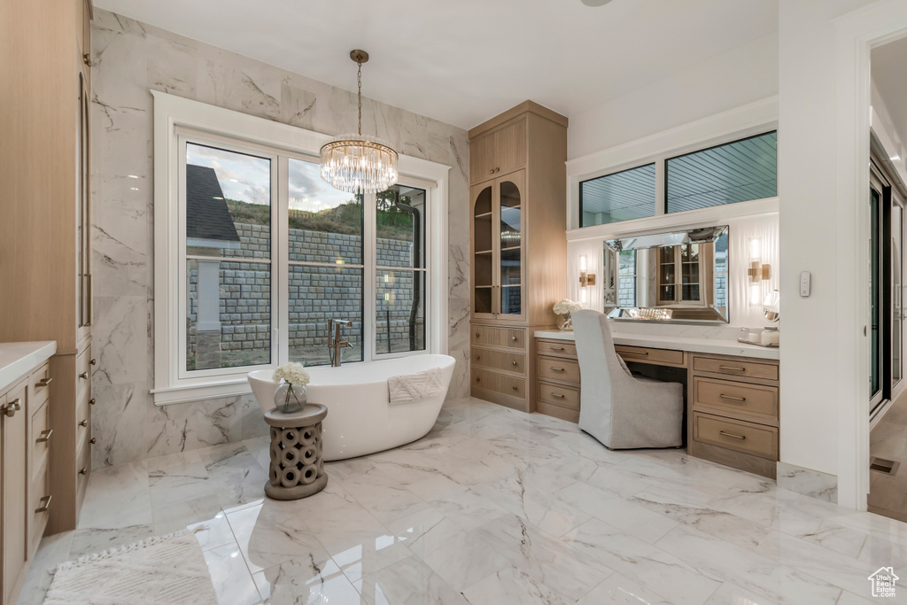 Full bathroom with vanity, marble tiled floors, and a freestanding bath