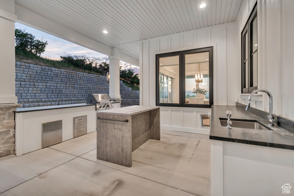 Bathroom with a sink, a decorative wall, recessed lighting, and wooden ceiling