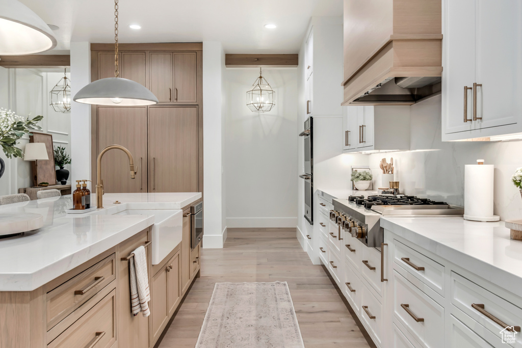 Kitchen featuring custom range hood, stainless steel appliances, a sink, baseboards, and recessed lighting