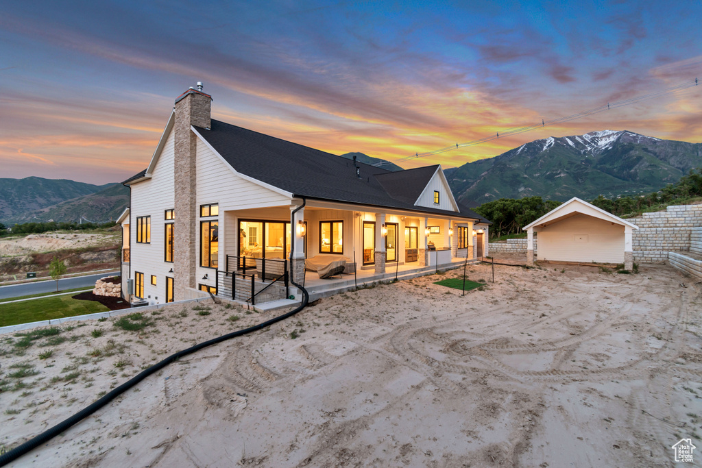 Back of house featuring a mountain view and a chimney