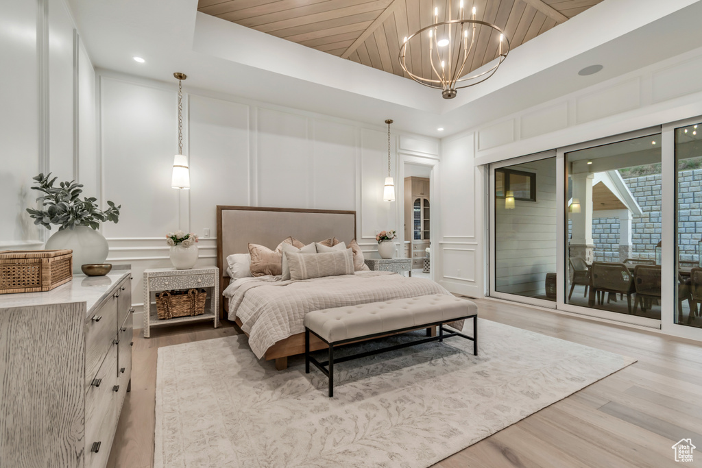 Bedroom with a decorative wall, light wood finished floors, access to exterior, a chandelier, and recessed lighting