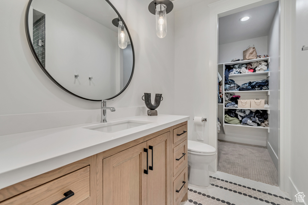 Bathroom with tile patterned floors, vanity, toilet, recessed lighting, and a closet