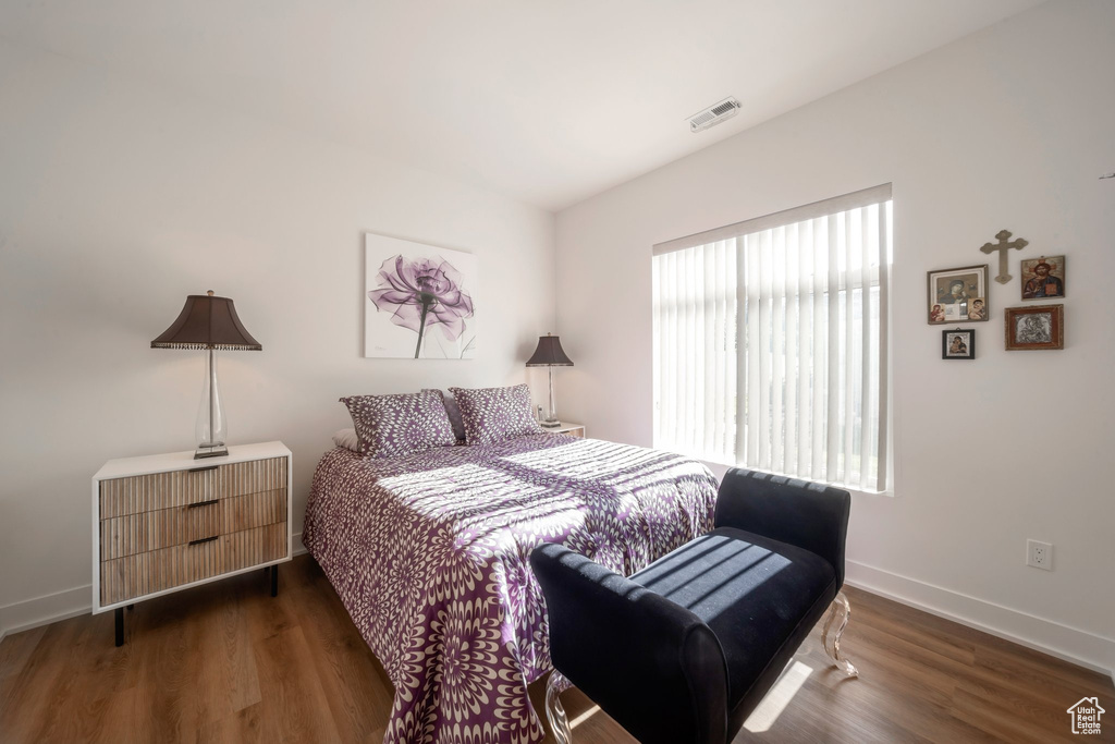 Bedroom with wood finished floors and baseboards