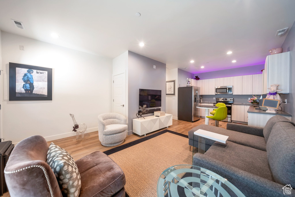 Living room featuring light wood-style floors, recessed lighting, and baseboards