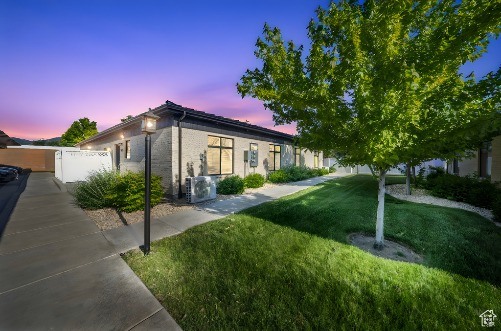 View of front of property featuring a cooling unit and brick siding
