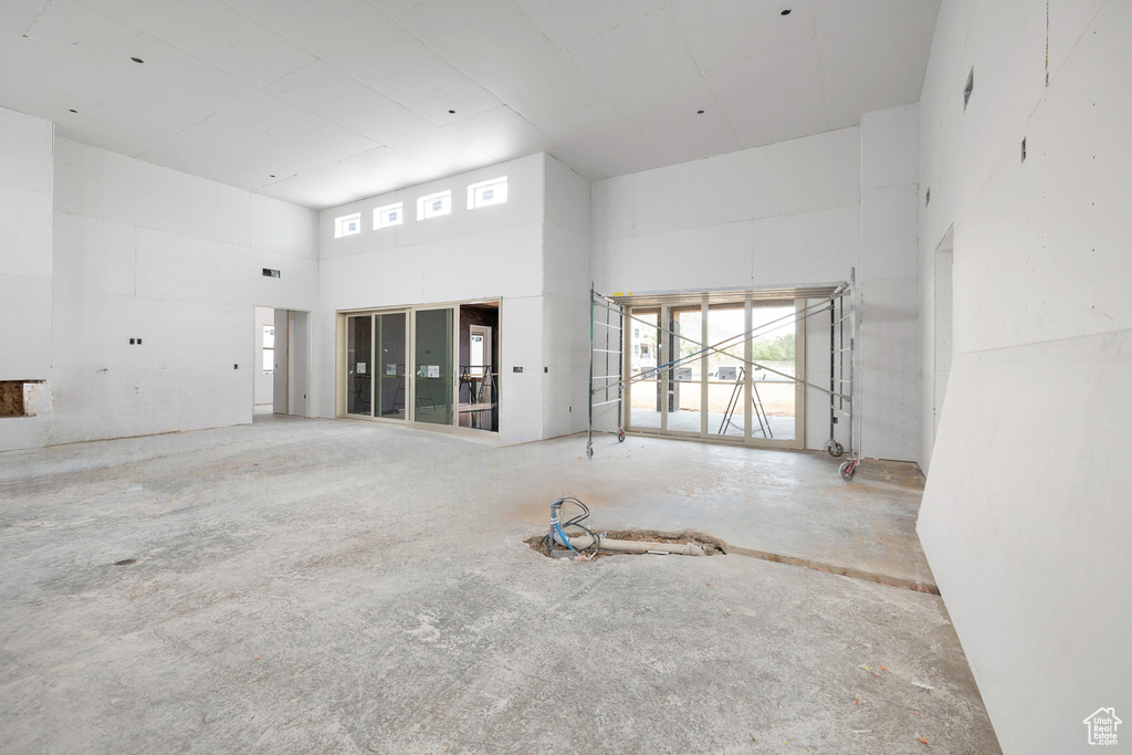 Empty room featuring a high ceiling and concrete flooring