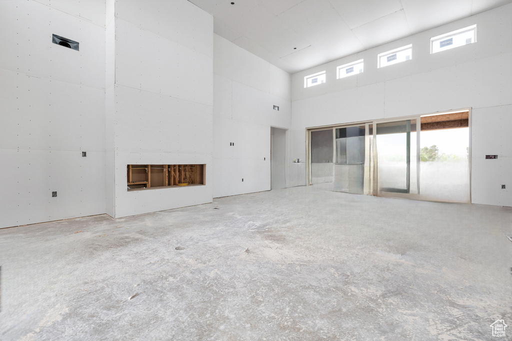 Spare room with a high ceiling and a fireplace