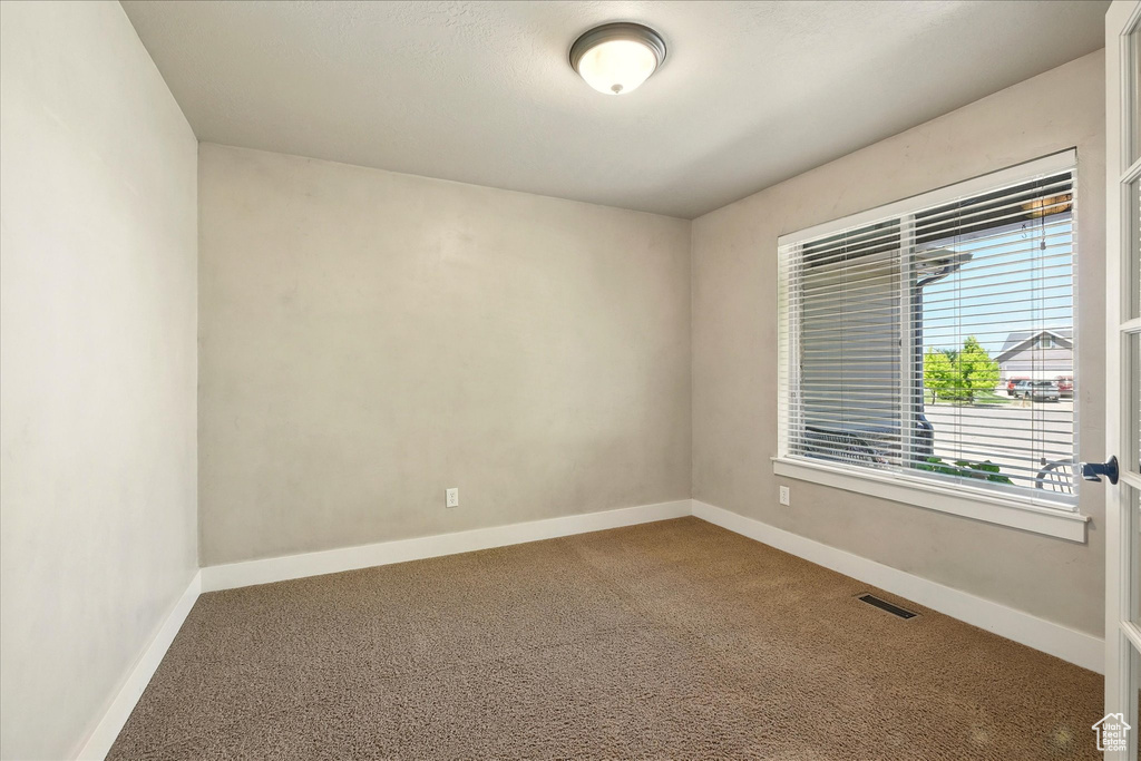 Empty room featuring carpet floors and baseboards