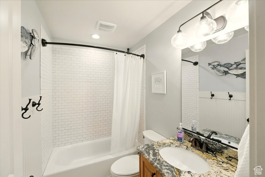 Full bath with toilet, vanity, and shower / bathtub combination with curtain