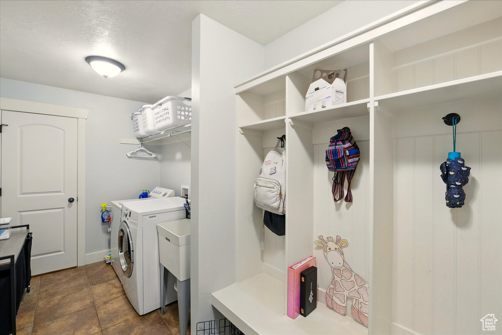 Washroom featuring independent washer and dryer and baseboards