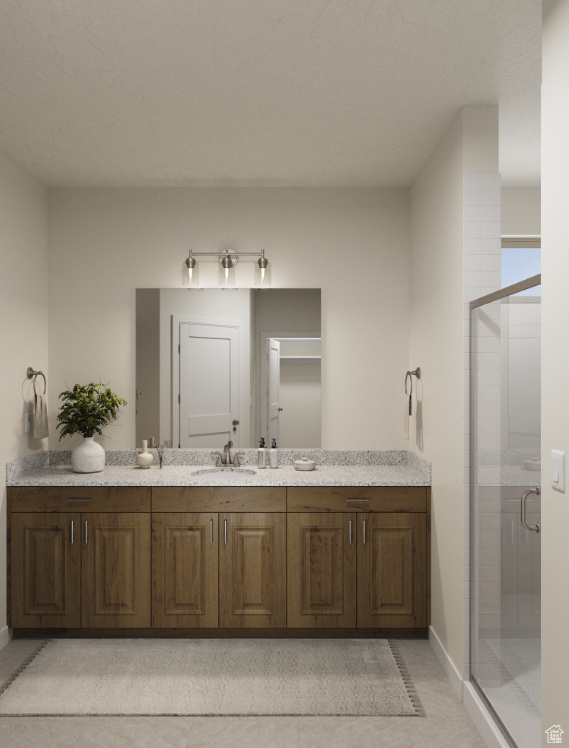 Full bathroom featuring a shower stall, vanity, and baseboards