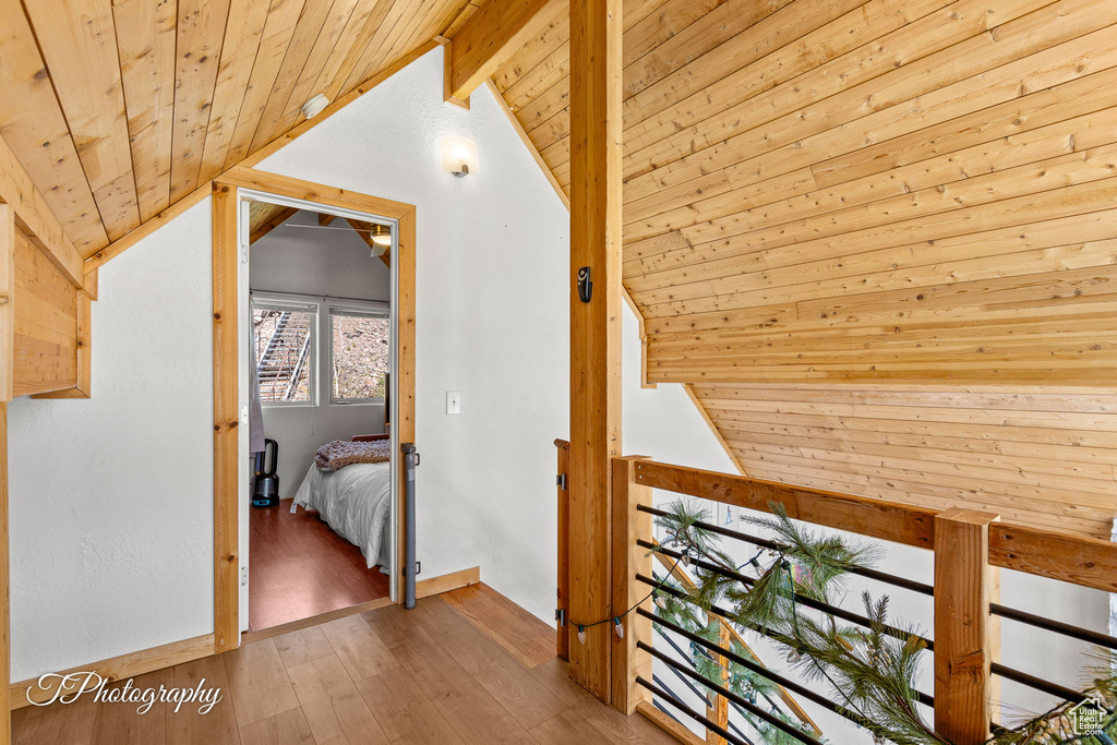 Hall featuring wooden ceiling, an upstairs landing, and hardwood / wood-style floors