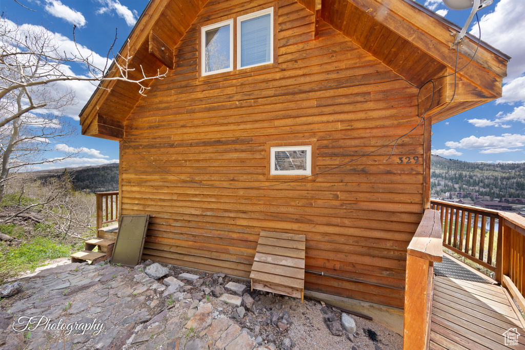 View of side of home featuring a wooden deck