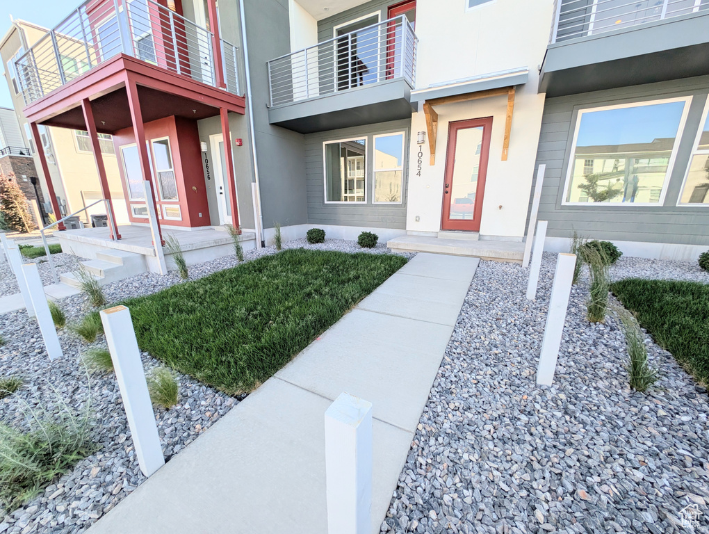 Entrance to property with a balcony and stucco siding